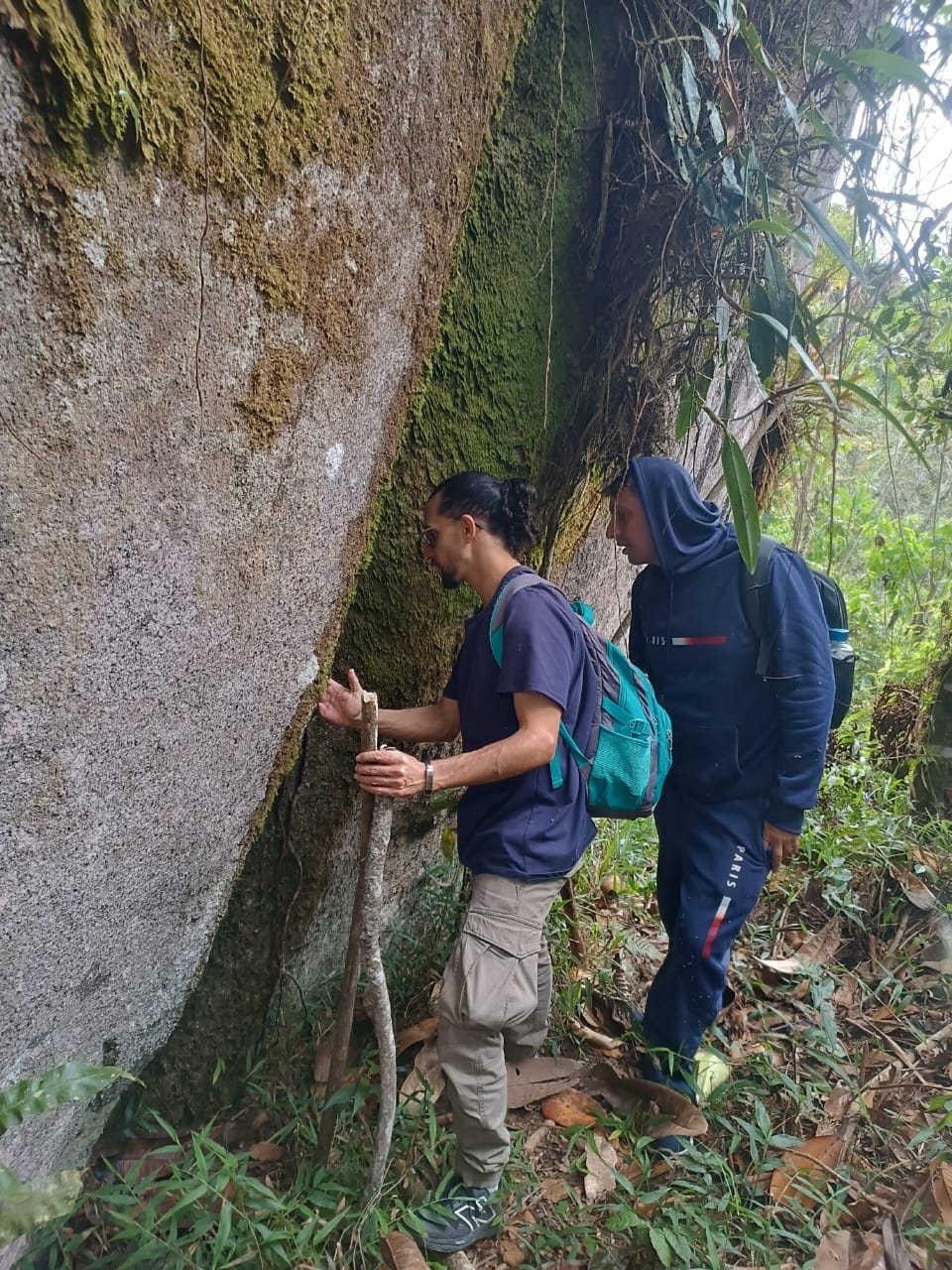 Caminantes recorriendo una roca cubierta de musgo en Guatapé